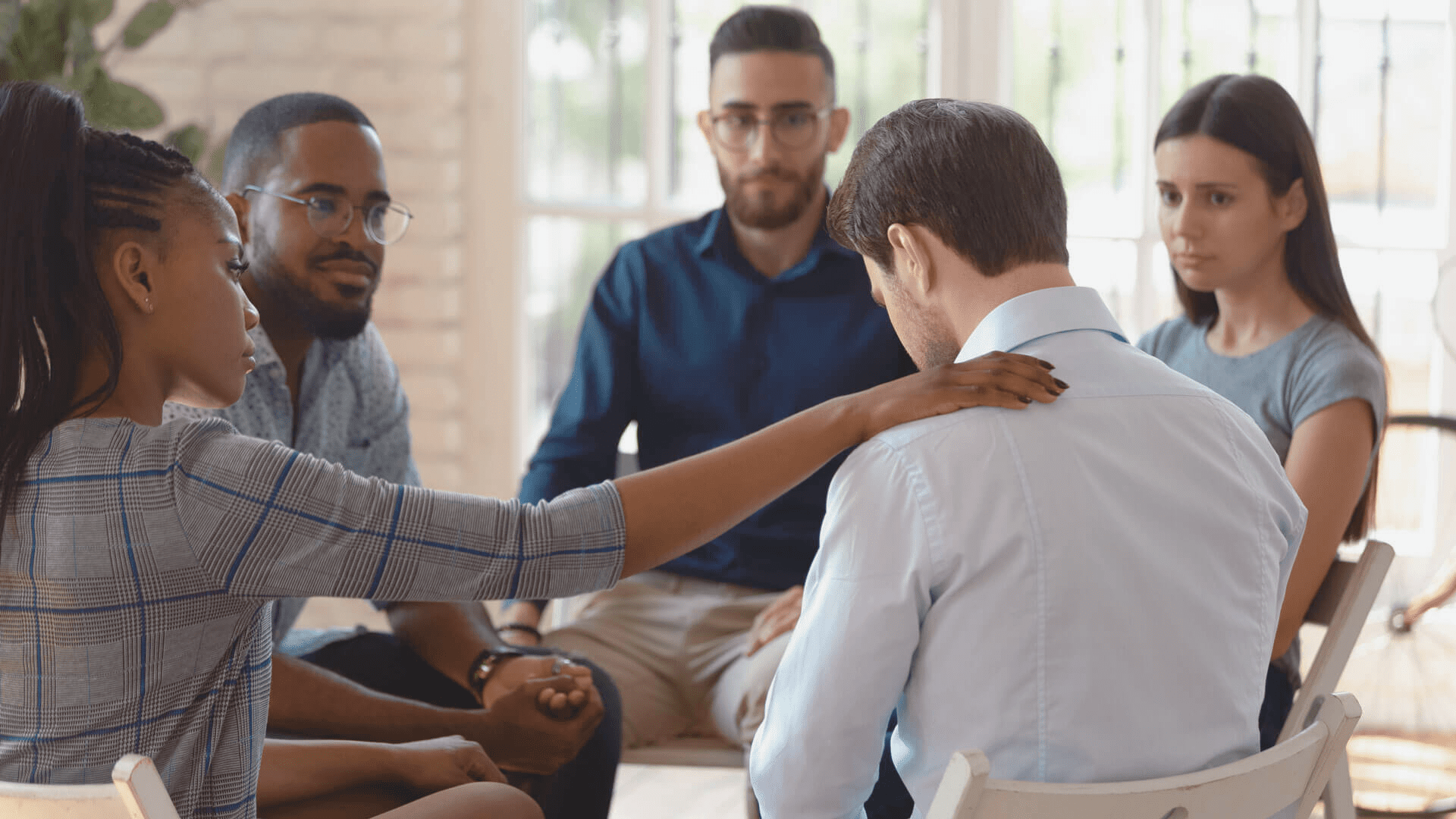 Diverse support group in a therapy session offering comfort and encouragement. Emotional healing and mental health counseling in a safe space.