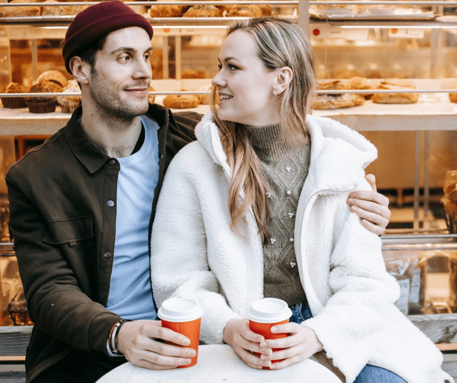 couples sitting outside of a bakeshop, drinking coffee