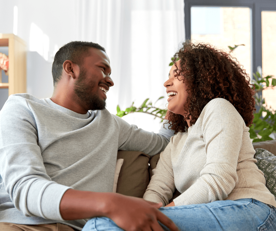 Happy couple sharing an intimate moment on the couch, enjoying a peaceful and loving connection