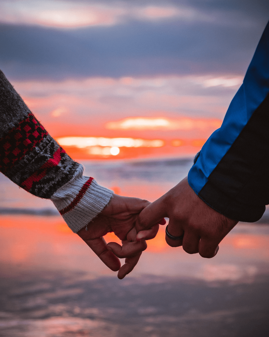 Couple holding hands at sunset, symbolizing relationship healing and emotional connection