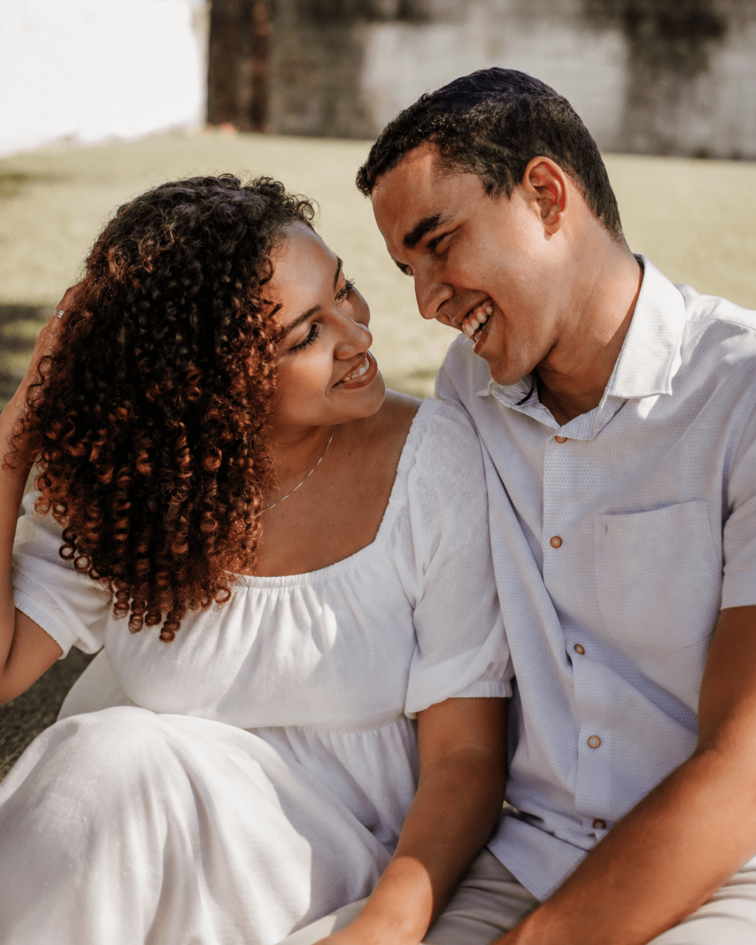 Couple smiling and enjoying a close, affectionate moment together outdoors